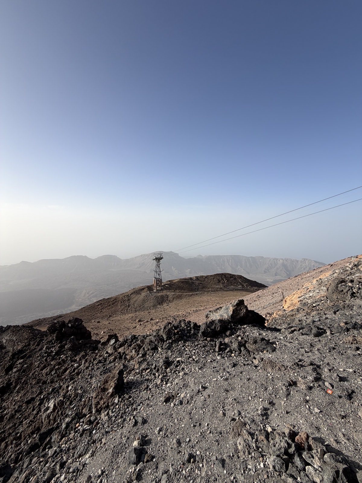 Teide cable car pylon standing on the volcanic ridge against a deep blue sky, photographed on the walk near the upper station